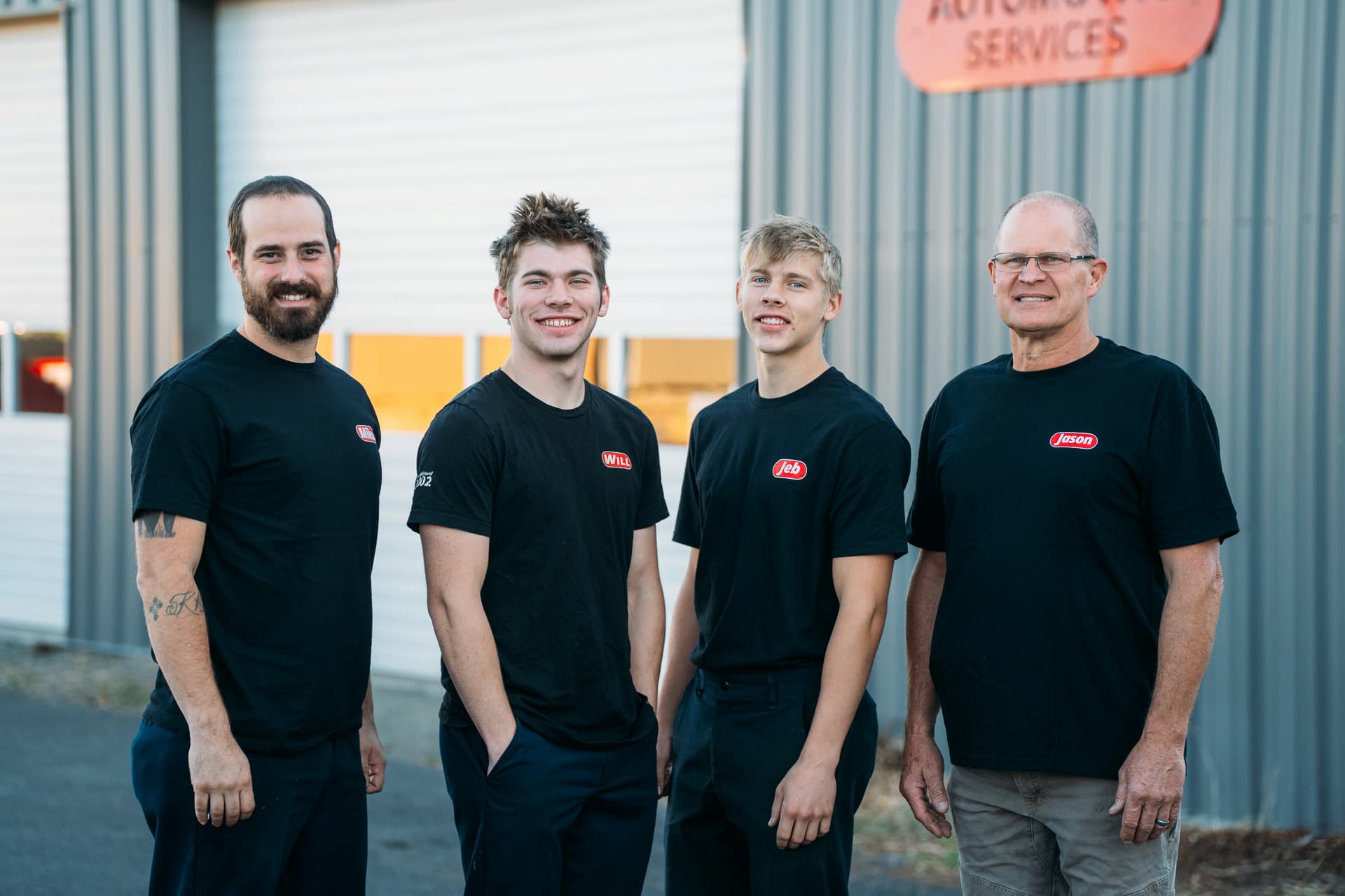 Mike, Will, Jeb and Jason standing in front of the shop in matching black Jantzer shirts